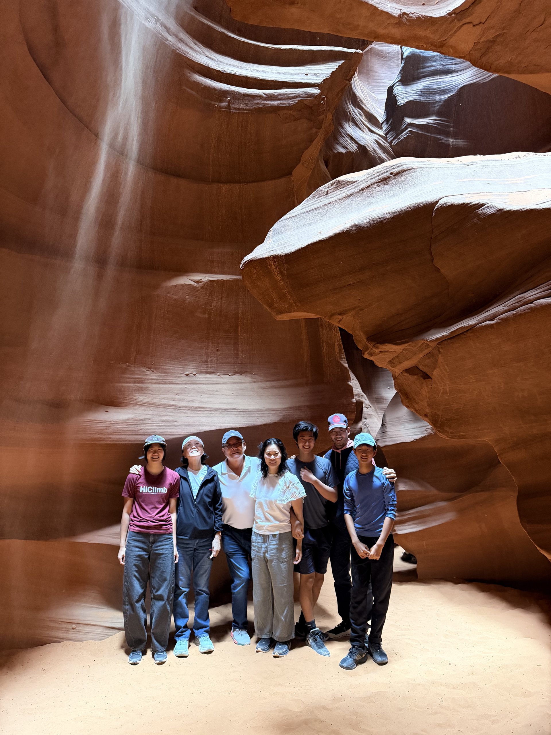 The family standing under a shaft of light in Upper Antelope Canyon