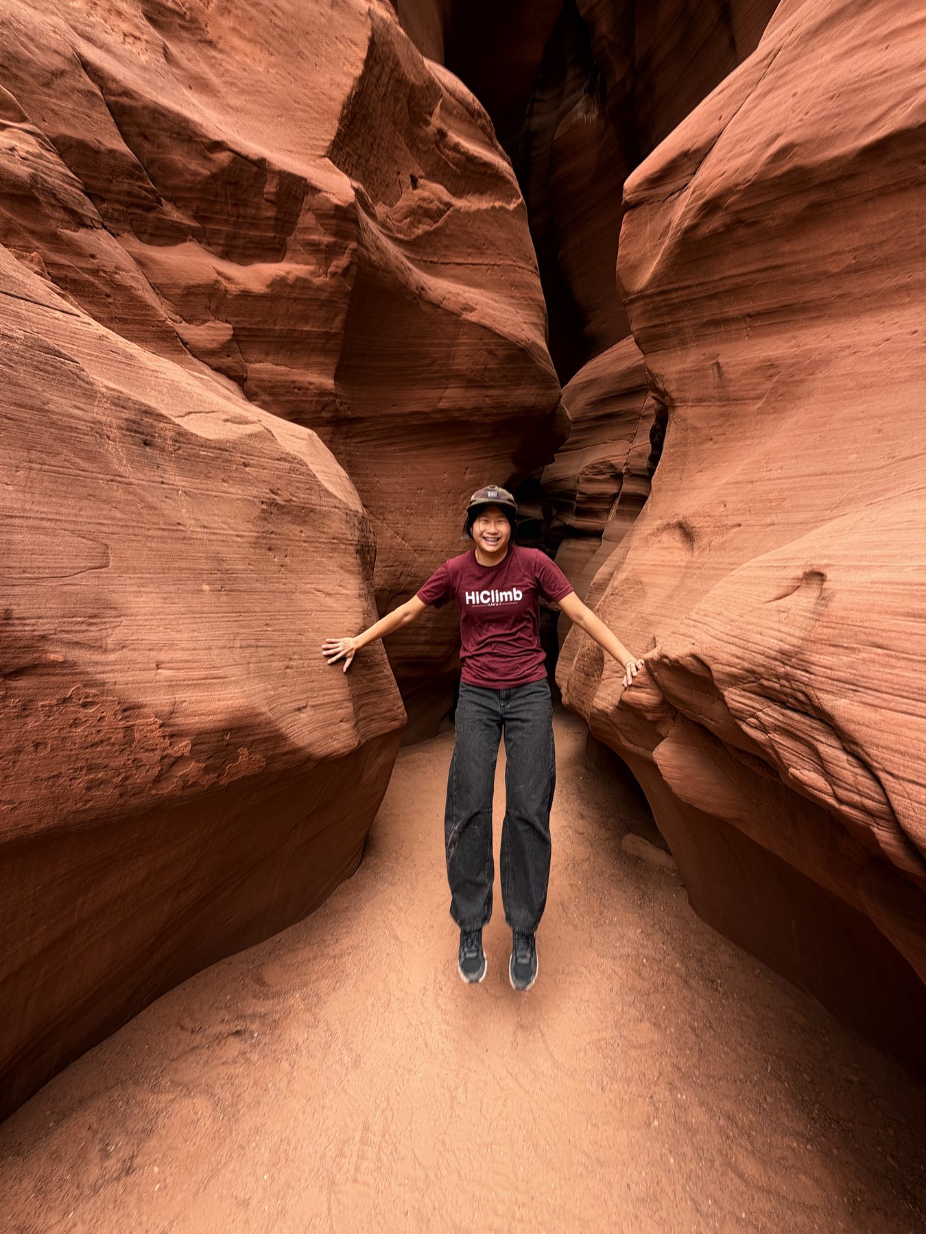 Arms out between the walls of Upper Antelope Canyon